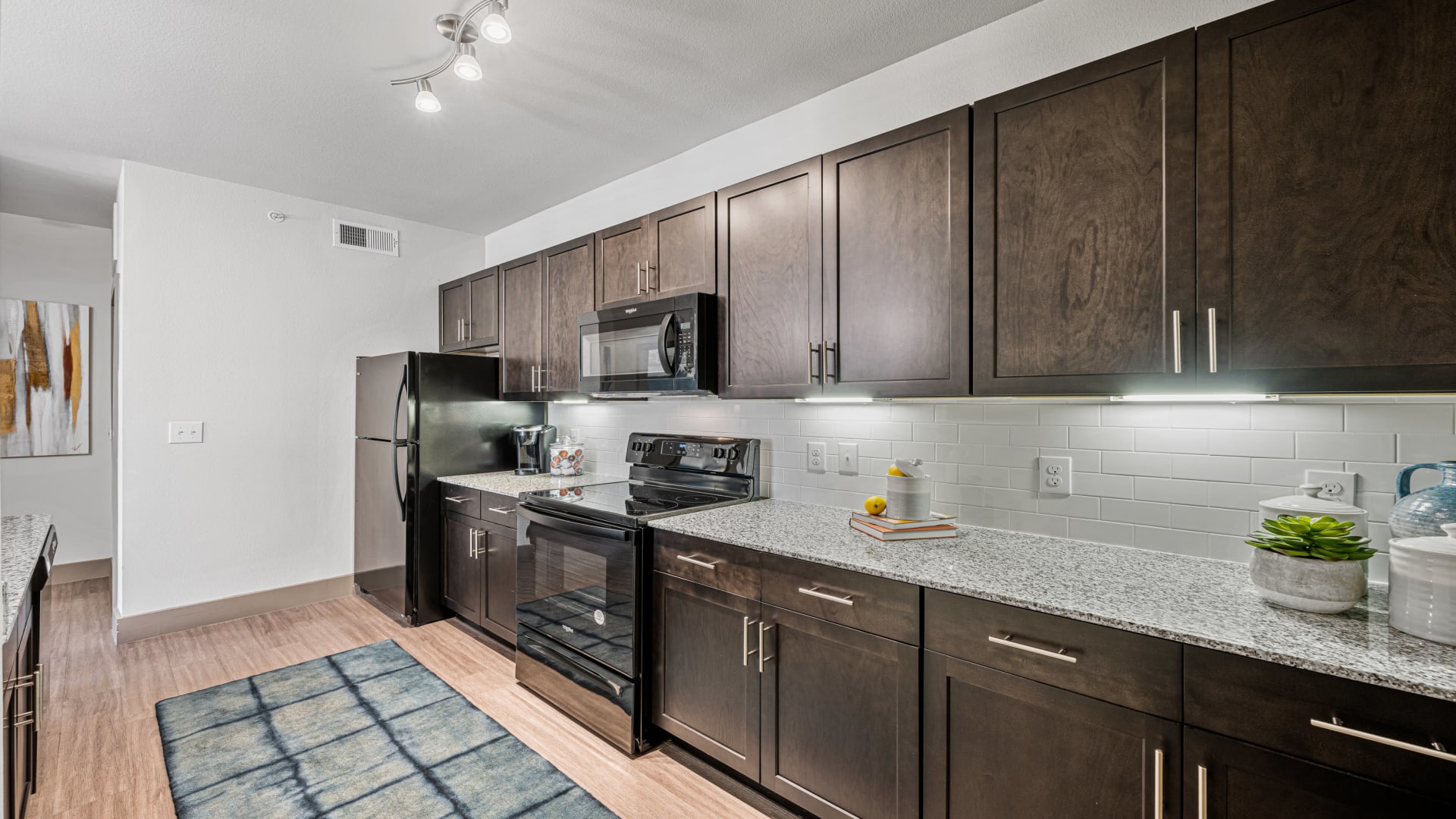 a kitchen with dark wood cabinets and stainless steel appliances at The Panr Hollow