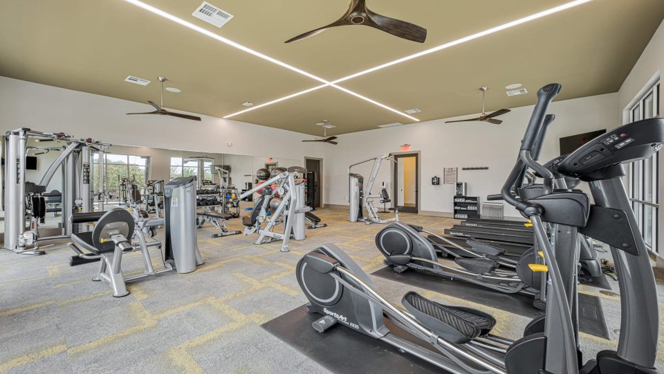 a gym room with tread machines and ceiling fans at The Panr Hollow